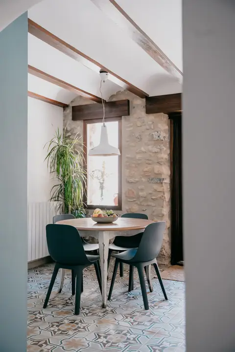 Office con mesa redonda, sillas y paredes de piedra