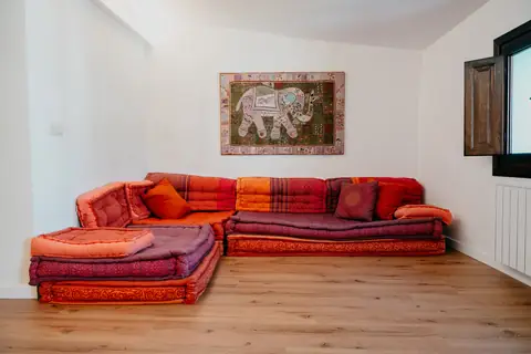 Zona diáfana con sofá bajo de colores cálidos