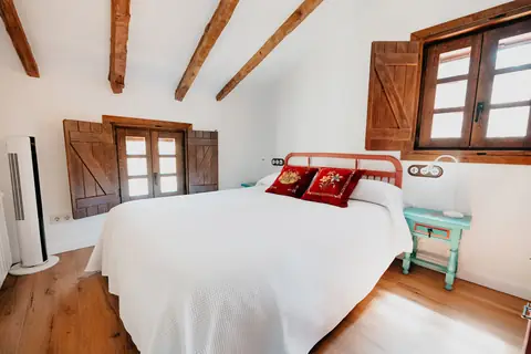 Dormitorio doble con ventanas de madera