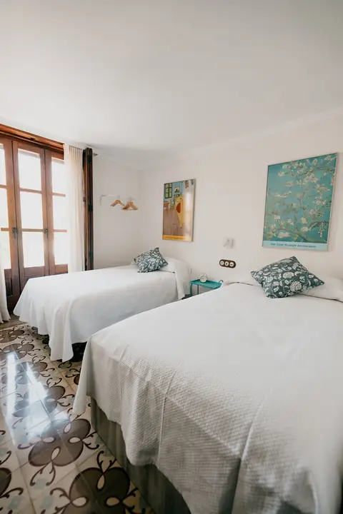 Habitación con dos camas y suelo hidráulico