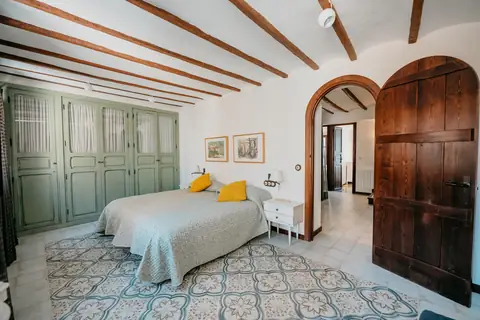 Dormitorio con armario verde y puerta en arco